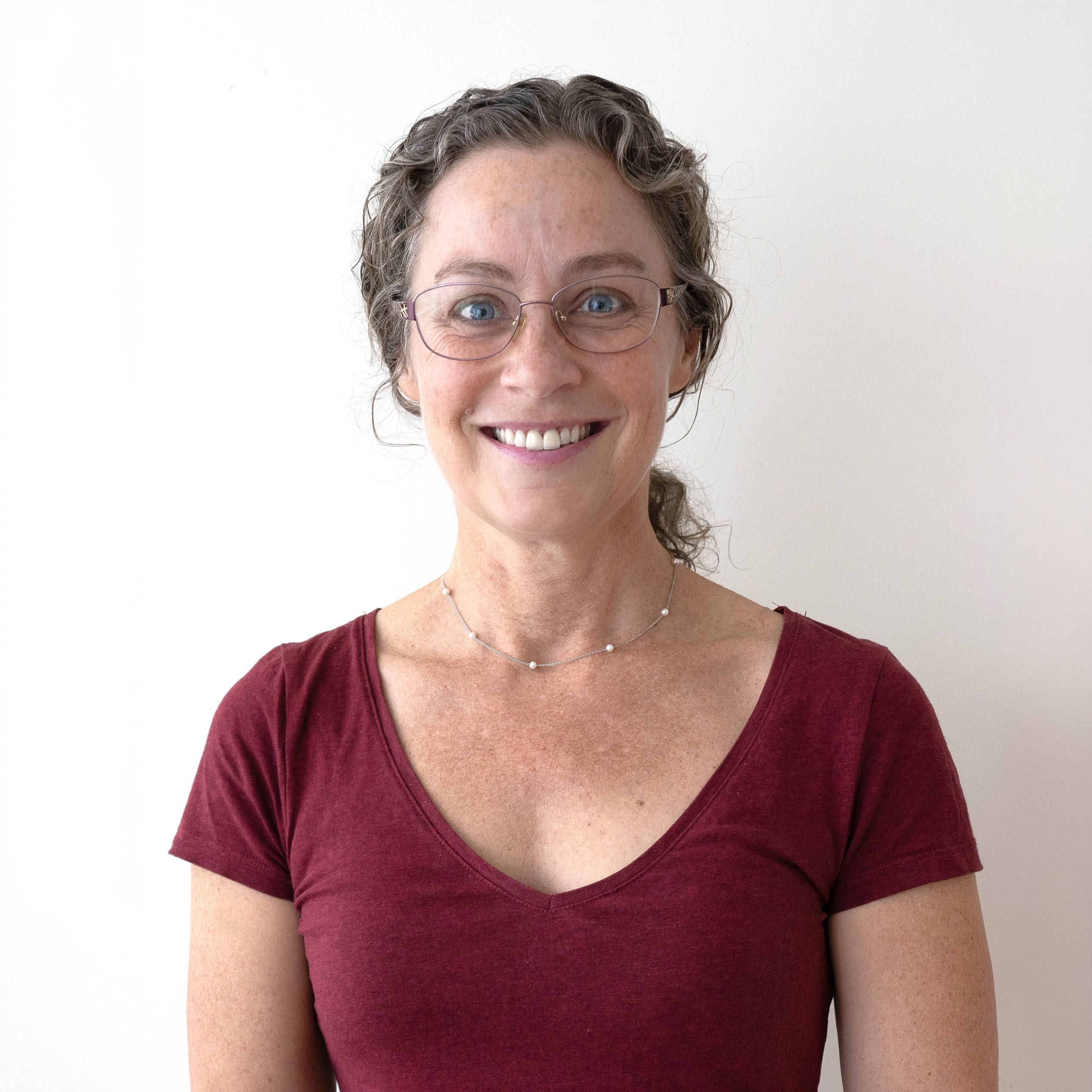 Maureen Curran - BC Green Party Candidate for New West-Coquitlam Maureen Curran, BC Green Party candidate for New West-Coquitlam, smiling in a portrait wearing glasses and a maroon shirt.